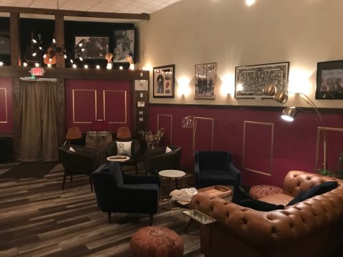 Cozy lounge area with plush seating, warm lighting, and framed artwork on the walls.