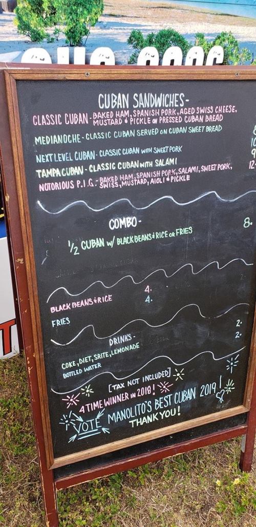 Chalkboard menu listing Cuban sandwiches, sides, and drinks, highlighting a combo option and award recognition.