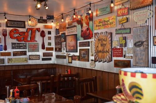 Cozy restaurant interior with rustic decor, wooden tables, and colorful signs on the walls, creating a warm atmosphere.