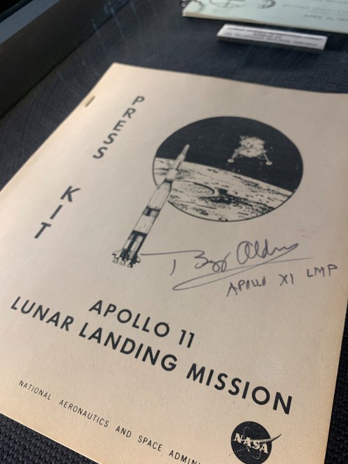 Press kit for Apollo 11 Lunar Landing Mission, featuring a rocket and lunar module illustration, signed by Buzz Aldrin.