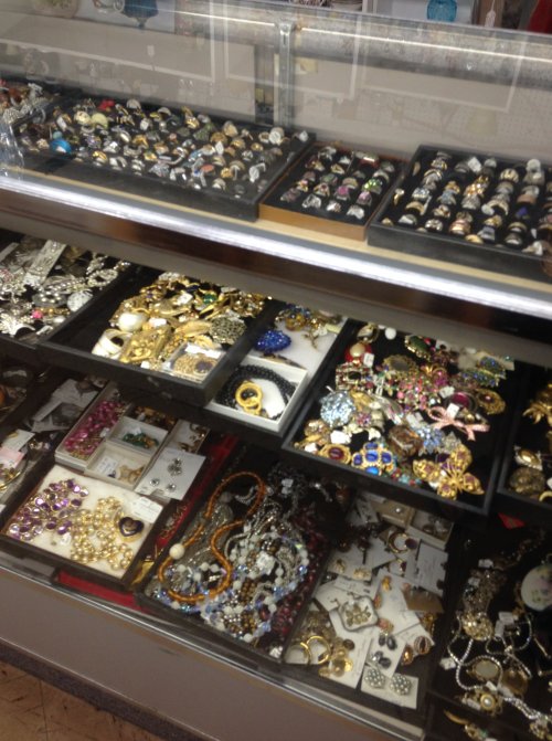 A display case filled with various rings, necklaces, and colorful jewelry pieces.