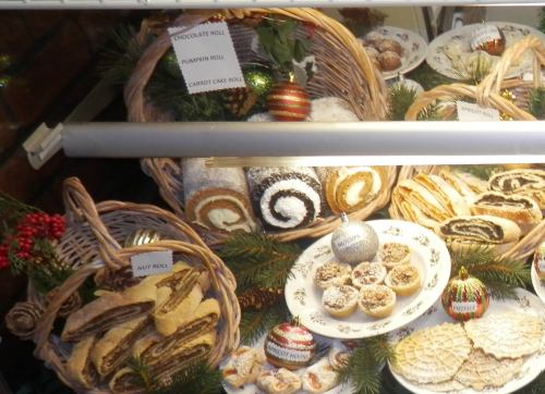 A display of festive baked goods, including rolls and pastries, arranged in baskets with holiday decorations.