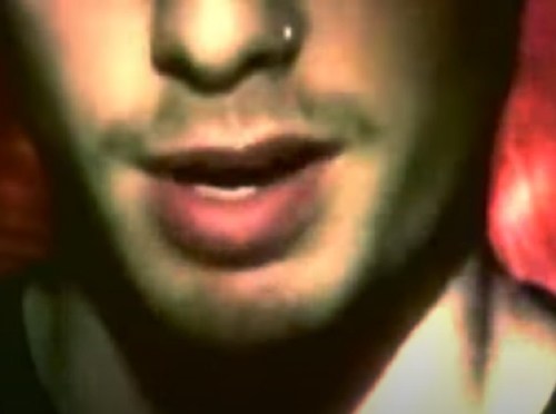 Close-up of a person's mouth and chin, with a blurred background in warm tones.