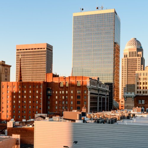 City skyline featuring a mix of modern and historic buildings under a clear blue sky.