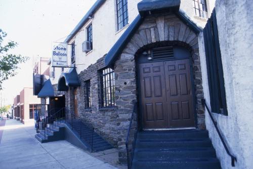 Exterior of the Stone Balloon venue, featuring a stone facade, double doors, and a sign above.