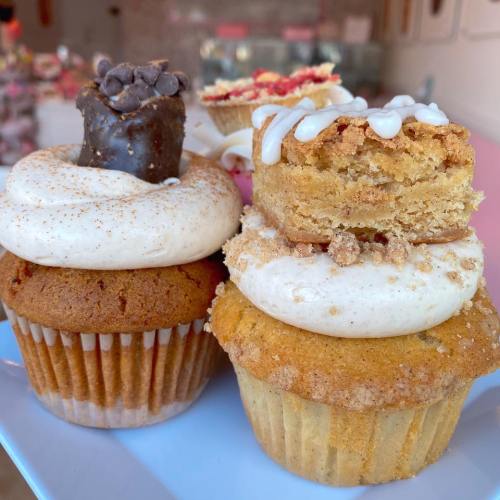 A close-up of two delicious cupcakes topped with frosting, one with chocolate and the other with a crumb topping.