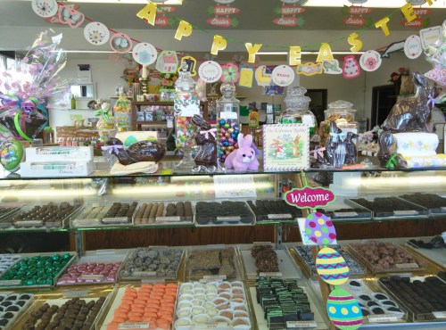 A colorful candy shop display filled with chocolates, Easter decorations, and festive treats.