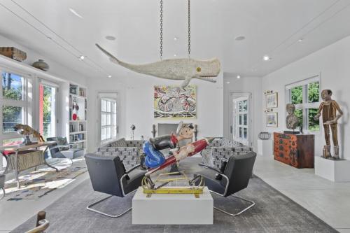 A modern living room featuring unique art pieces, a whale sculpture, and playful decor in a bright, airy space.