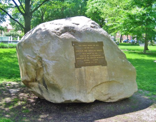 A large rock in a park with a plaque commemorating the site of the Lincoln-Douglas debate, August 27, 1858.