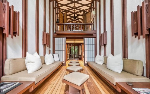 A spacious, modern interior with wooden beams, cozy seating, and natural light, creating a serene atmosphere.