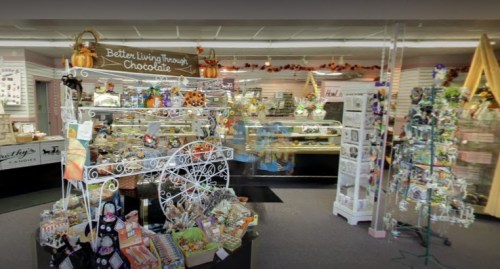 A cozy gift shop filled with colorful decorations, candy displays, and seasonal items, creating a warm atmosphere.