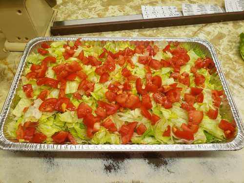 A large tray filled with chopped lettuce and diced tomatoes, ready for serving.