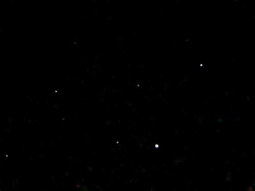 A dark night sky filled with scattered stars, some shining brightly against the black backdrop.