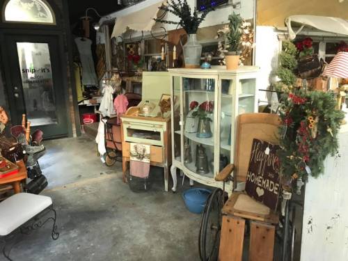A cozy vintage shop interior with various antique furniture, decor, and a welcoming atmosphere.
