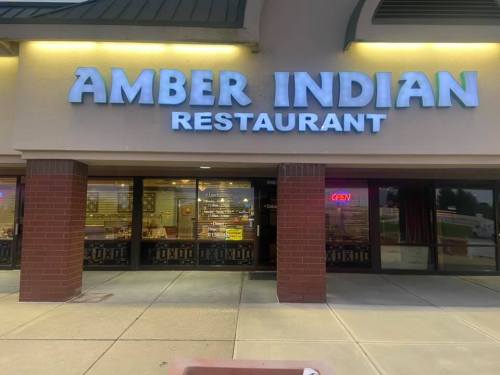 Sign for Amber Indian Restaurant, featuring illuminated letters and an "OPEN" neon sign in the window.