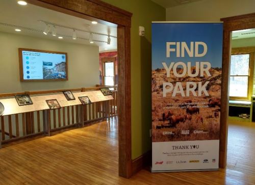Interior of a park visitor center featuring a "Find Your Park" banner and informational displays on the walls.