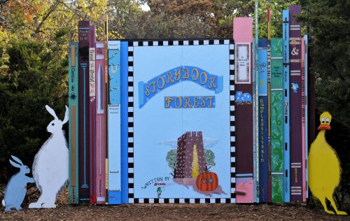 Colorful display of oversized books and whimsical characters, featuring a sign that reads "Storybook Forest."