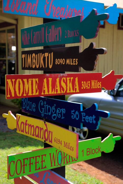Colorful directional signpost with distances to various locations, including Nome, Alaska, and Timbuktu.