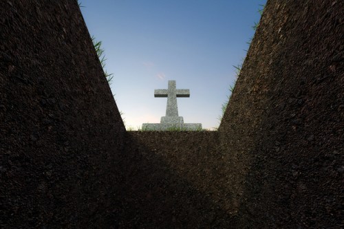A view from inside a grave, looking up at a cross against a clear blue sky.