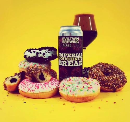 A colorful assortment of donuts with a can of Evil Twin Brewing's Imperial Doughnut Break and a glass of dark beer.