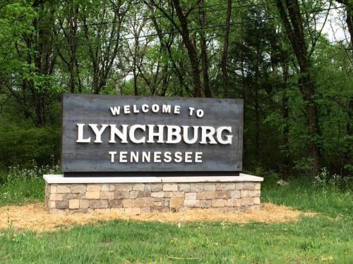Welcome sign for Lynchburg, Tennessee, surrounded by greenery and natural scenery.