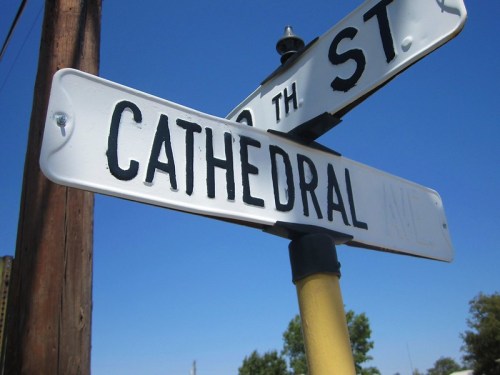 Street sign for "Cathedral Ave" at the intersection with "10th St" against a clear blue sky.