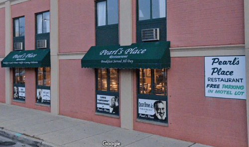 Exterior of Pearl's Place restaurant with green awnings, signage, and a parking notice in a motel lot.