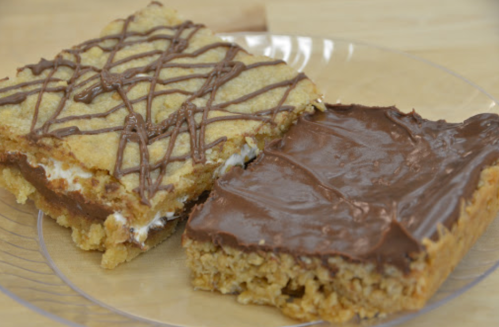 Two dessert bars on a plate: one with a chocolate drizzle on top and the other with a smooth chocolate layer.