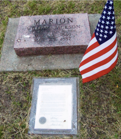 Gravestone of William Jackson Marion, with dates May 13, 1849 - March 25, 1887, and a U.S. flag nearby.