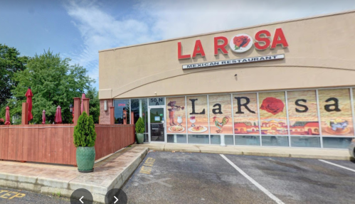 Exterior view of La Rosa Mexican Restaurant, featuring a patio with red umbrellas and vibrant signage.