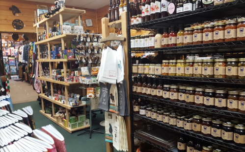 A cozy shop interior filled with shelves of jars, snacks, and various merchandise, creating a warm, inviting atmosphere.