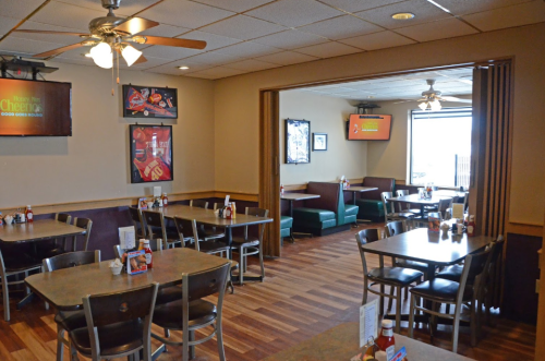 Interior of a casual dining restaurant with tables, chairs, and a cozy booth area, featuring sports memorabilia on the walls.