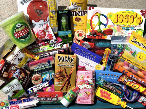 A colorful assortment of nostalgic candies and snacks, including Pocky, M&Ms, and various novelty treats.