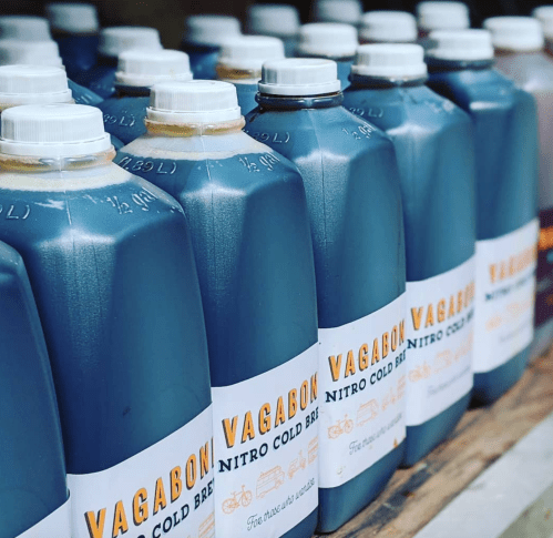 A row of bottles labeled "Vagabon Nitro Cold Brew" filled with dark cold brew coffee.