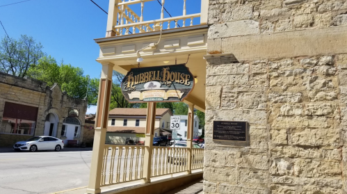 Sign for Hubbell House on a historic building, with a view of the street and nearby structures.