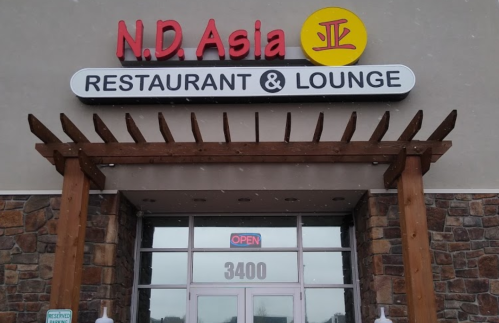 Sign for N.D. Asia Restaurant & Lounge, featuring a red and yellow logo, with an "Open" sign in the window.