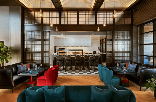 Modern restaurant interior featuring stylish seating, a bar area, and warm lighting.