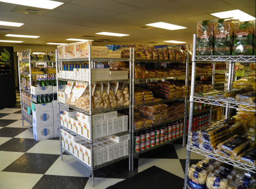 A grocery store aisle with shelves stocked with various packaged foods and products, featuring a checkered floor.