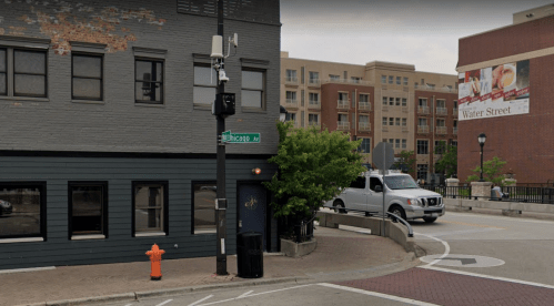 Street view of a corner building with a Chicago street sign, a fire hydrant, and a truck on a road near a residential area.