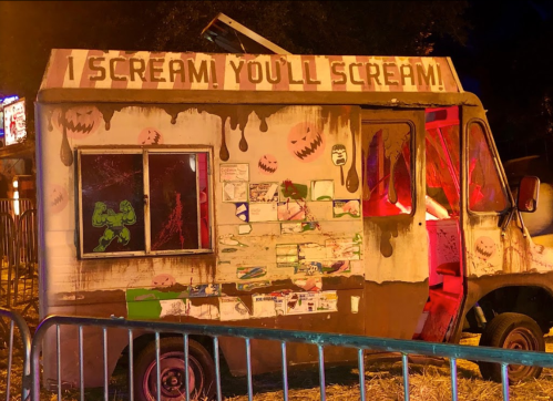 A spooky ice cream truck with a sign reading "I SCREAM, YOU'LL SCREAM!" and dripping chocolate decorations.