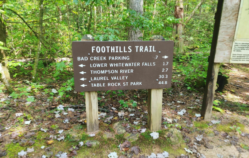 Signpost for Foothills Trail with distances to various locations: Bad Creek Parking, Lower Whitewater Falls, Thompson River, Laurel Valley, Table Rock St Park.