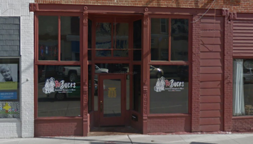 Front view of a restaurant with large windows and a red facade, featuring the name "Bucks" on the signage.