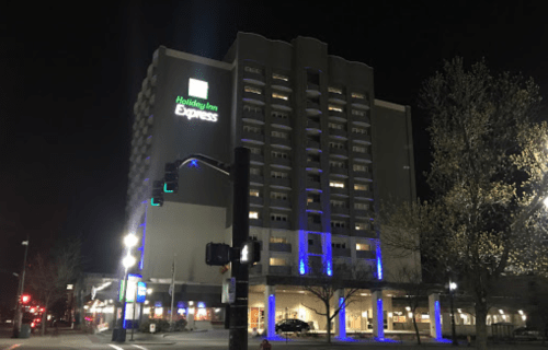 A Holiday Inn Express hotel at night, featuring illuminated signage and a modern architectural design.