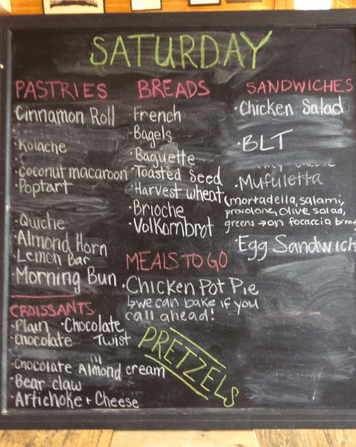 Menu for Saturday: pastries, breads, sandwiches, and meals to go, including cinnamon rolls, bagels, and chicken pot pie.