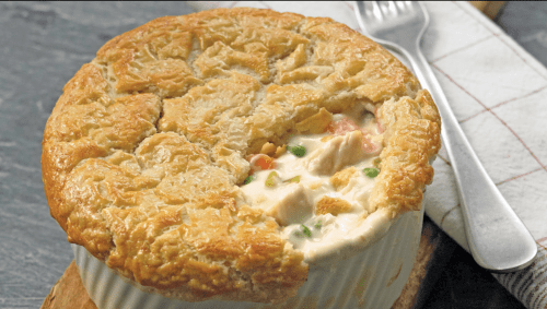 A golden-brown chicken pot pie with a flaky crust, filled with creamy chicken, vegetables, and herbs.