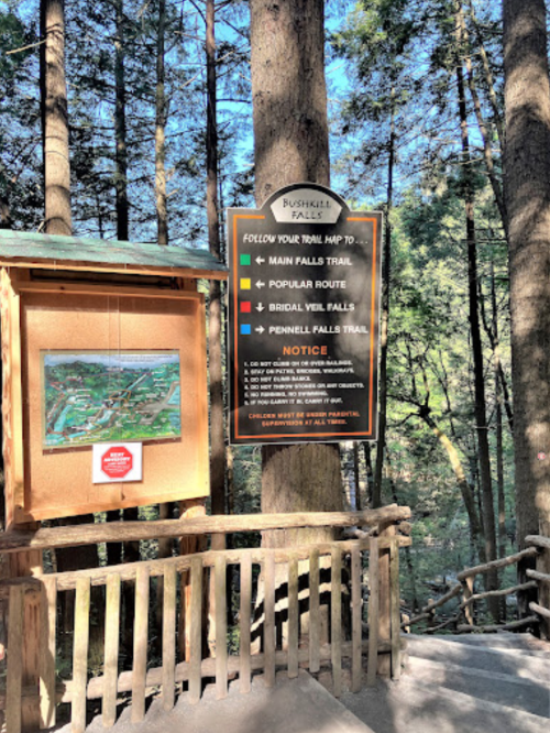 Signpost at Bushkill Falls with trail map and directions to Main Falls, Bridal Veil Falls, and Pennell Falls Trail.