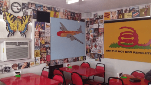 Colorful diner interior featuring a butterfly mural, airplane artwork, and walls adorned with various quirky images.