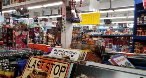 A colorful store interior filled with various merchandise, including signs, toys, and souvenirs on display.