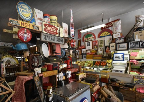 A vintage general store filled with retro signs, old-fashioned goods, and colorful displays of fruits and memorabilia.