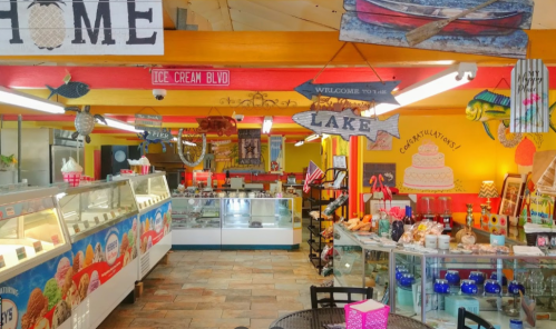 Colorful ice cream shop interior with vibrant decor, display cases, and signs, creating a cheerful atmosphere.